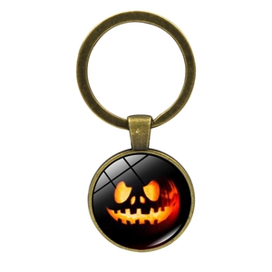 Close-up of vintage bronze Halloween keychain with glowing pumpkin cabochon design
