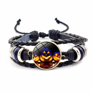 Dettaglio del bracciale intrecciato retrò con cabochon in vetro Jack-o'-lantern