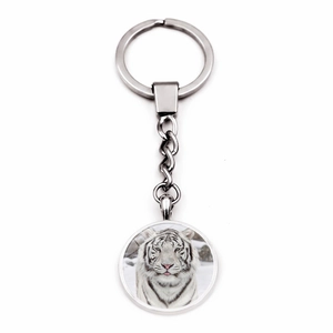 Detailed close-up of a silver keychain featuring a realistic white tiger glass cabochon
