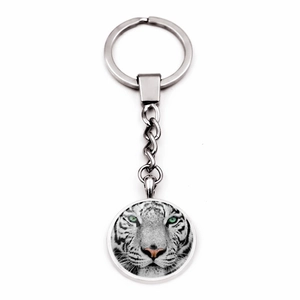 Detailed view of silver tiger keychain with clear glass gemstone pendant on white background