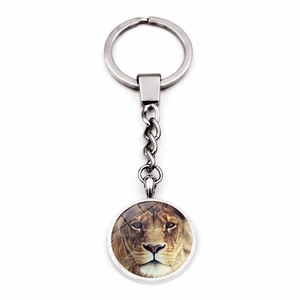 Macro detail of silver metal keychain featuring a creative lion head glass dome pendant