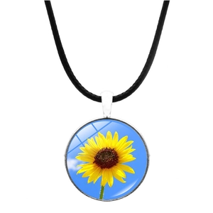 Gros plan détaillé d'un pendentif tournesol avec motif ciel bleu et cordon noir