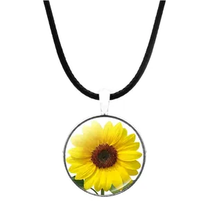 Détail du collier pendentif en verre tournesol avec cordon noir sur fond blanc
