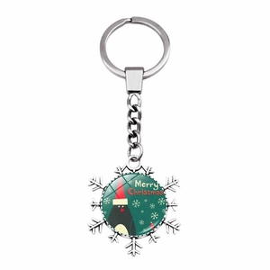 Macro detail of snowflake keychain with festive penguin and Merry Christmas text