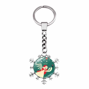 Close-up of snowflake keychain with a red-haired angel illustration on green background