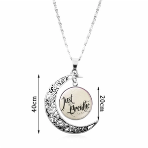 Just Breathe silver crescent moon necklace with glass gem and intricate floral patterns