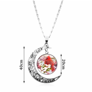 Silver crescent moon cardinal necklace with glass cabochon pendant on white background