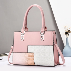 Detailansicht der rosa Patchwork-Handtasche mit Krokostruktur und Jacquard-Gewebe