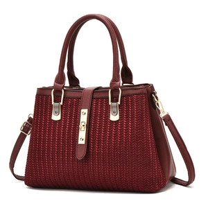 Dettaglio della trama intrecciata e finiture dorate su borsa da donna bordeaux