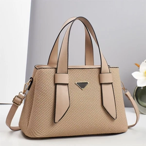 Detail of contrast stitch tote with woven texture, golden hardware and adjustable strap