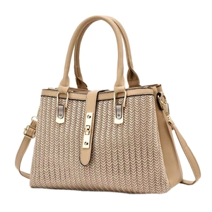 Elegante borsa a mano beige testurizzata con tracolla rimovibile vista da un angolo di 45 gradi