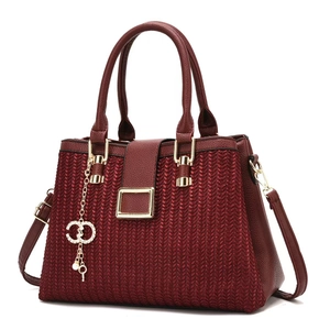 Detailed close-up of wine red woven texture handbag with golden hardware and key pendant