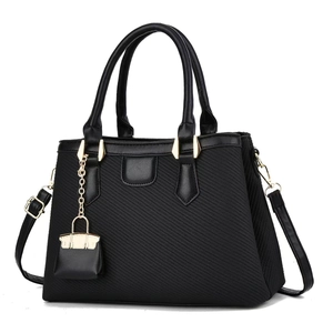Detail of black macaron handbag showing textured fabric, golden chain and mini charm