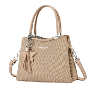Beige textured woven tote bag with adjustable leather strap and star charm accessory