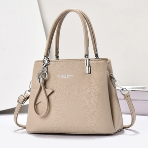 Detail of beige lychee grain texture and metal hardware on a stylish tote bag