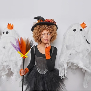 Λεπτομέρεια στολής μάγισσας Halloween με τούλινο φόρεμα, καπέλο και μωβ διακοσμητική σκούπα