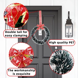 Detail of Christmas wreath with red bow and PET greenery on a black wooden door