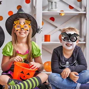 Παιδιά που φορούν χάρτινα γυαλιά Halloween με σχέδια κολοκύθας και νυχτερίδας σε πάρτι