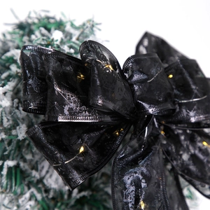 Dettaglio di un fiocco di Halloween in pizzo nero con luci LED su rami di pino