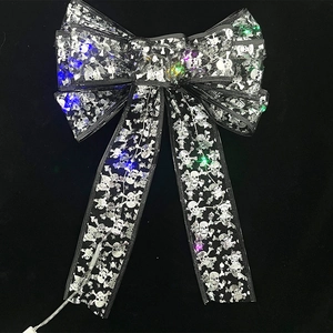 Dettaglio del fiocco nero di Halloween con teschi d'argento e luci LED multicolore