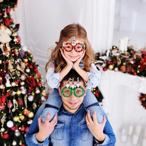 Adult and child wearing festive Santa and Gnome Christmas glasses for party celebrations