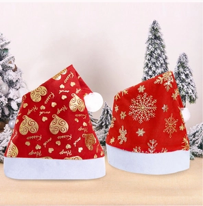 Detail view of red Christmas hats with gold snowflake and heart prints in a snowy setting