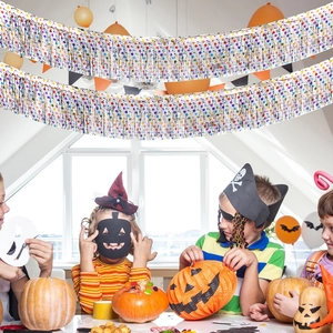 Colorful star foil fringe curtain hanging over children in Halloween party scene