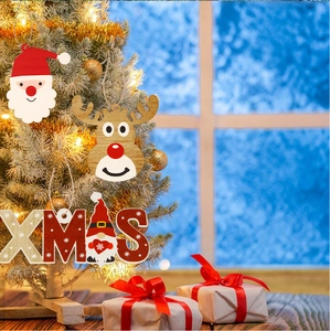 Détail de suspensions de Noël en bois peint avec Père Noël et élan sur un sapin festif