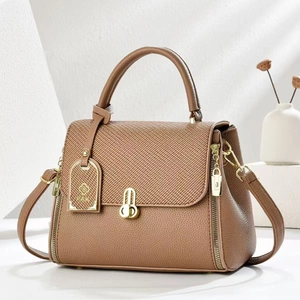 Brown leather and fabric crossbody handbag with metal U-lock on a clean white background