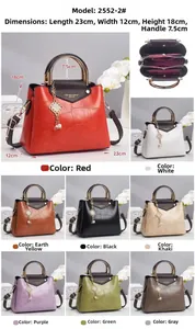 Detailed view of crocodile pattern leather handbag with metal ring handles and color options