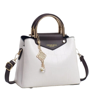White crocodile pattern tote bag with brown accents and gold ring handle shown from 45-degree angle