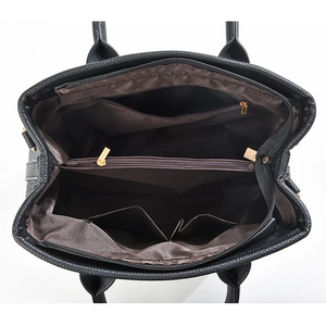 Interior view of black litchi leather handbag with brown fabric lining and zip compartment