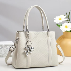 Detailansicht der cremeweißen Steppleder-Handtasche mit kreativem Silber-Hundeanhänger