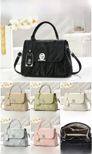 Detailed views of ruched shoulder bag with twist lock and internal compartments