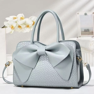Light blue bow handbag with crocodile pattern texture and golden hardware details