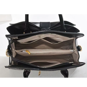 Macro view of the multi-compartment interior layout in a black faux leather handbag
