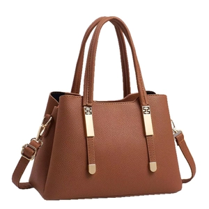 Caramel brown leather tote bag with gold hardware and adjustable strap on white background