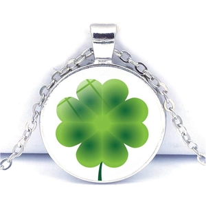 Gros plan d'un collier pendentif trèfle à quatre feuilles argenté avec gemme verte