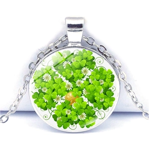 Détail macro du pendentif en alliage argenté avec trèfle à quatre feuilles et pièce