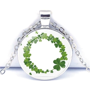 Détail du pendentif rond en verre avec motif trèfle vert et chaîne en alliage argenté
