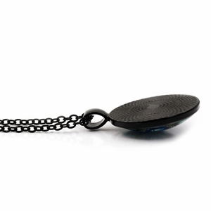 Detail of black alloy necklace featuring a textured back and blue-green glass cabochon