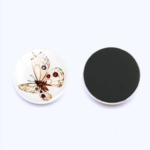 Detailed view of round butterfly fridge magnet showing decorative glass front and magnetic back