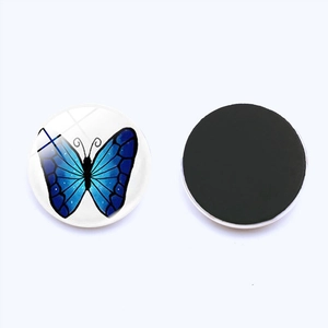 Detail view of 25mm glass butterfly fridge magnet showing front pattern and magnetic back