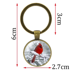 Vintage bronze keychain with Northern Cardinal bird glass dome pendant and snow branch motif