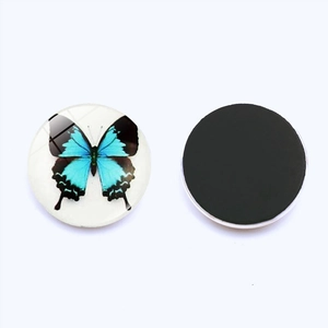 Macro detail of 25mm round glass magnet showing butterfly print and magnetic back