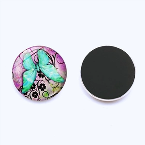 Detail of 25mm glass fridge magnet showing mint butterfly pattern and black magnetic back