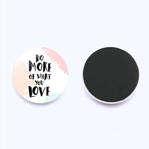Détail d'un aimant de frigo rond en verre avec citation Do More Of What You Love