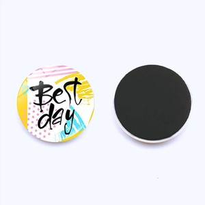 Détail d'un aimant en verre rond avec design Best Day et dos magnétique noir sur fond blanc