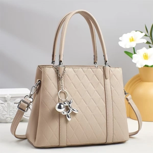 Quilted beige tote bag with silver balloon dog charm and adjustable shoulder strap