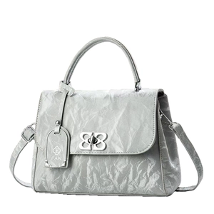 Silver metallic pleated handbag with a petal-shaped lock and adjustable shoulder strap